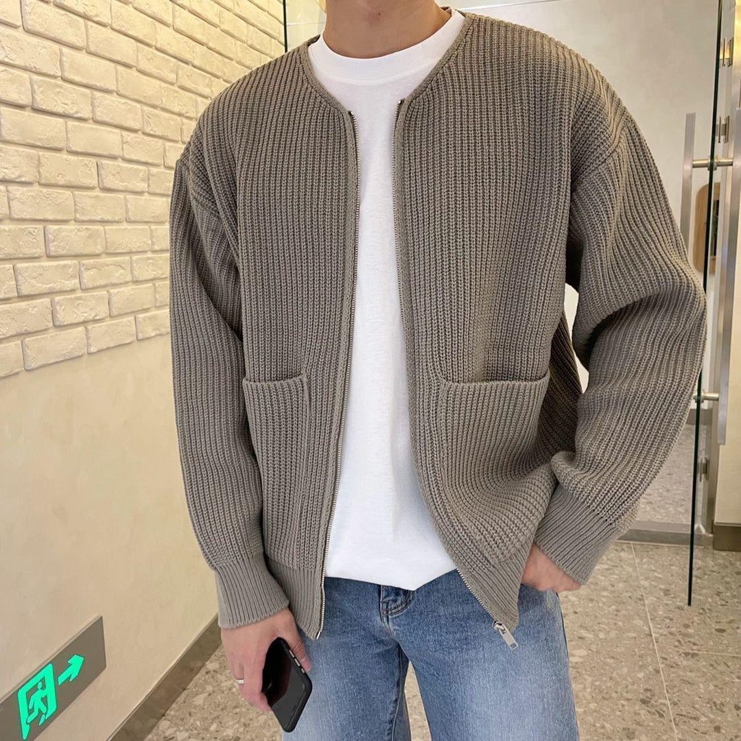 Daan taupe ribgebreide rits vest, close-up met telefoon