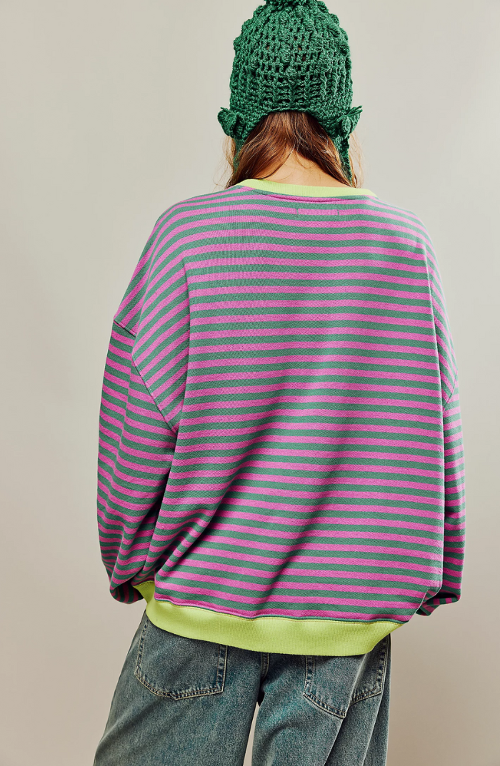 Fien gestreepte oversized sweater met groene en roze strepen, achteraanzicht met gebreide muts
