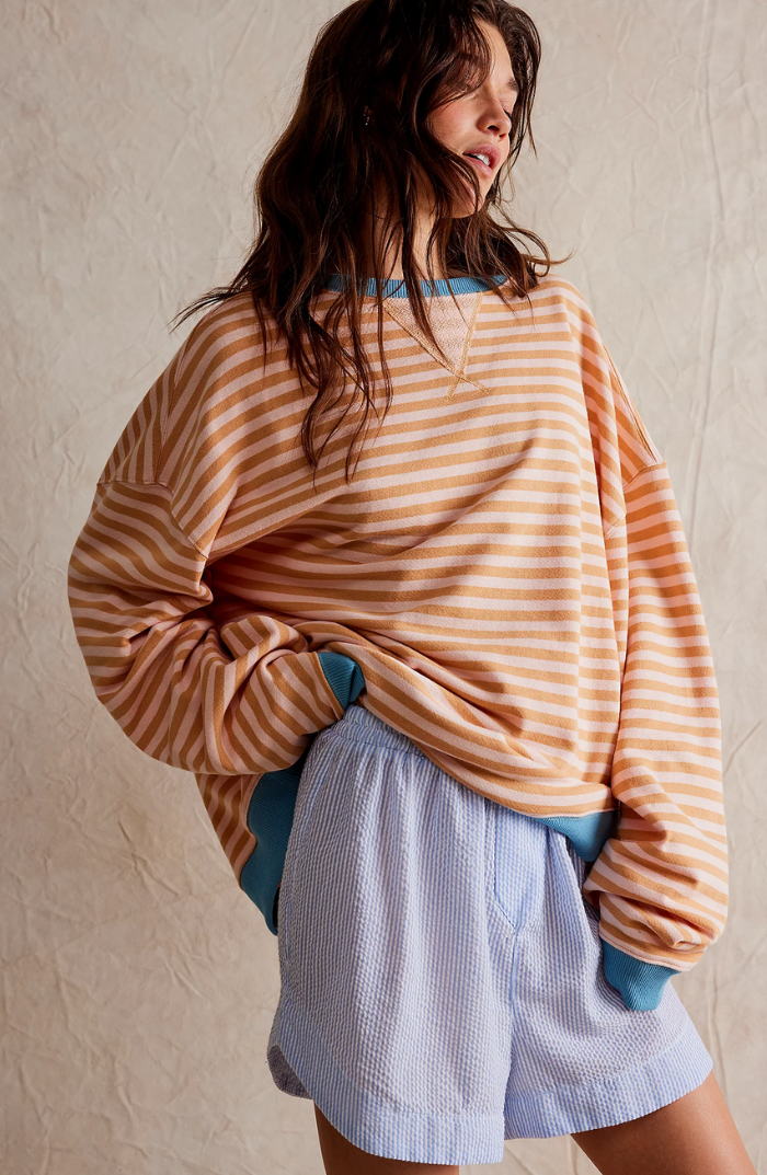Fien gestreepte oversized sweater in oranje en wit, achteraanzicht met blauwe boorden