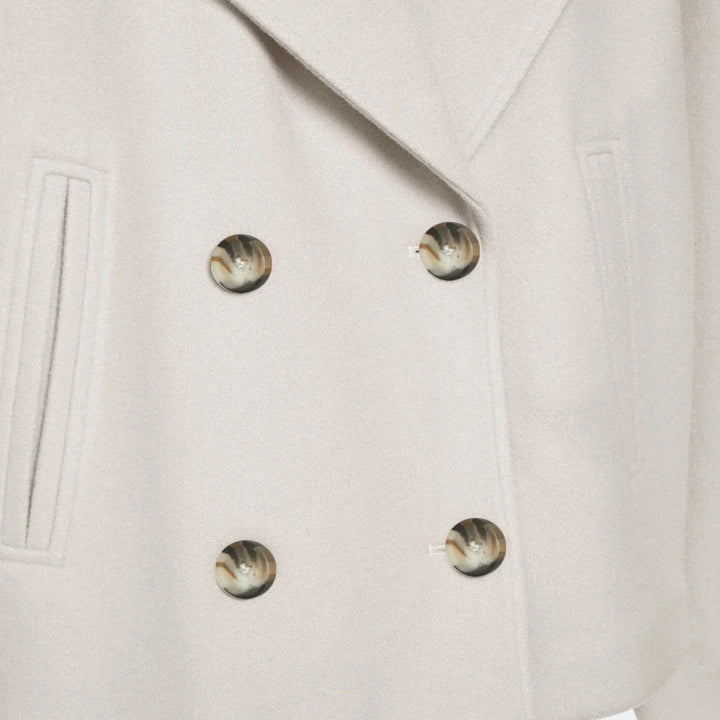 Loïs close-up knopen beige jas