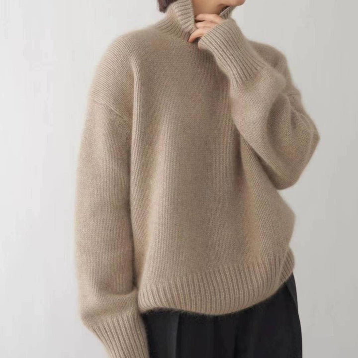 Marit oversized coltrui in beige, vooraanzicht met hand bij kraag