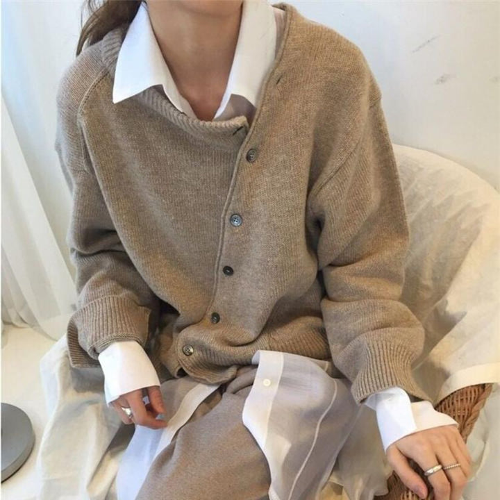 Noor beige gebreide cardigan gedragen op een stoel, detail