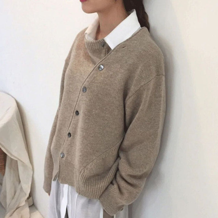 Noor beige gebreide cardigan, zijaanzicht tegen muur