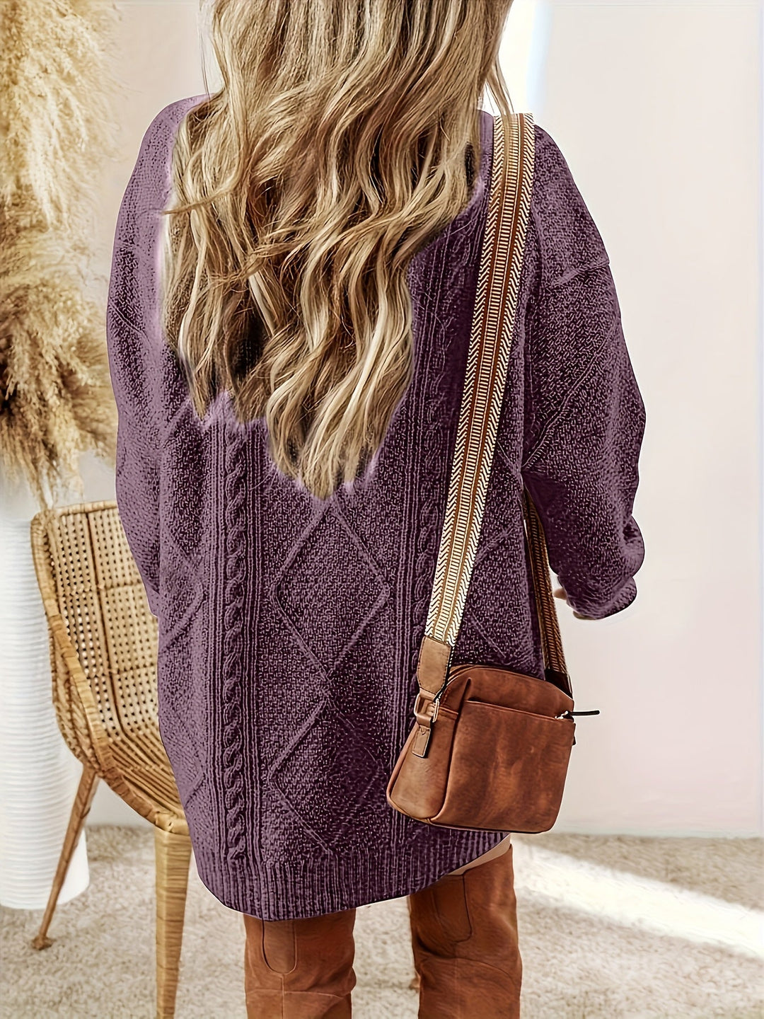 Achteraanzicht van paarse kabelbrei trui-jurk met crossbody tas