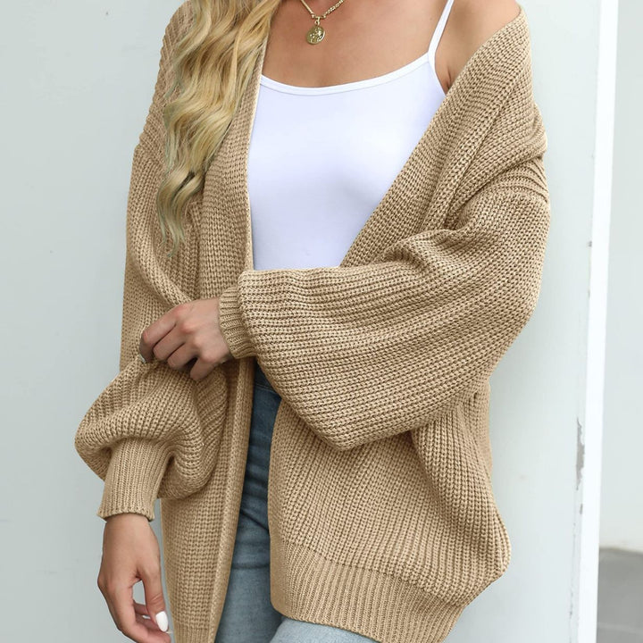 Silke oversized gebreid vest in beige, gedragen met witte top en spijkerbroek