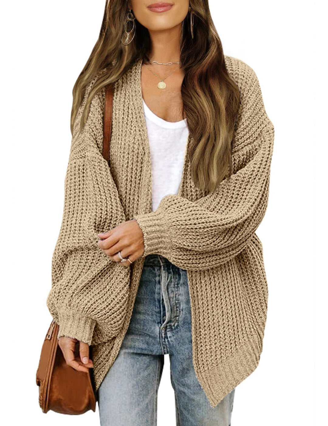 Silke oversized gebreid vest in beige, vooraanzicht met spijkerbroek